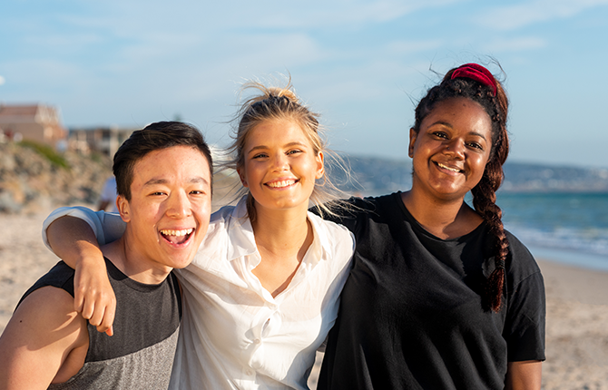 Three international students at a beach